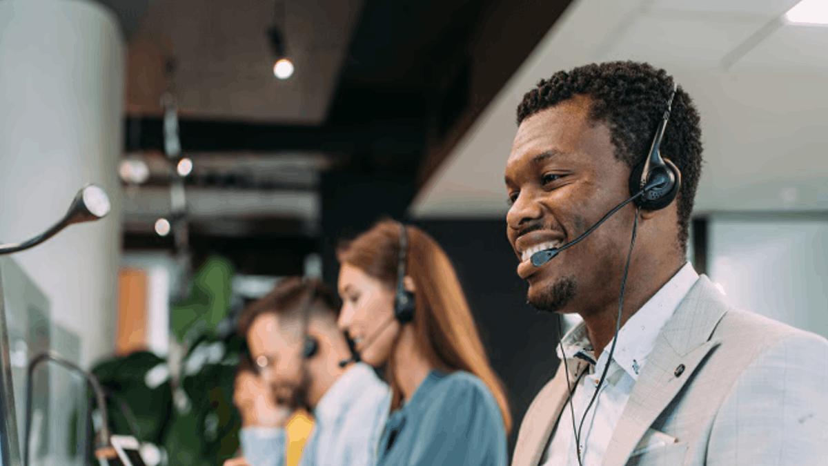 Customer service agents wearing headsets assisting clients in a modern office environment