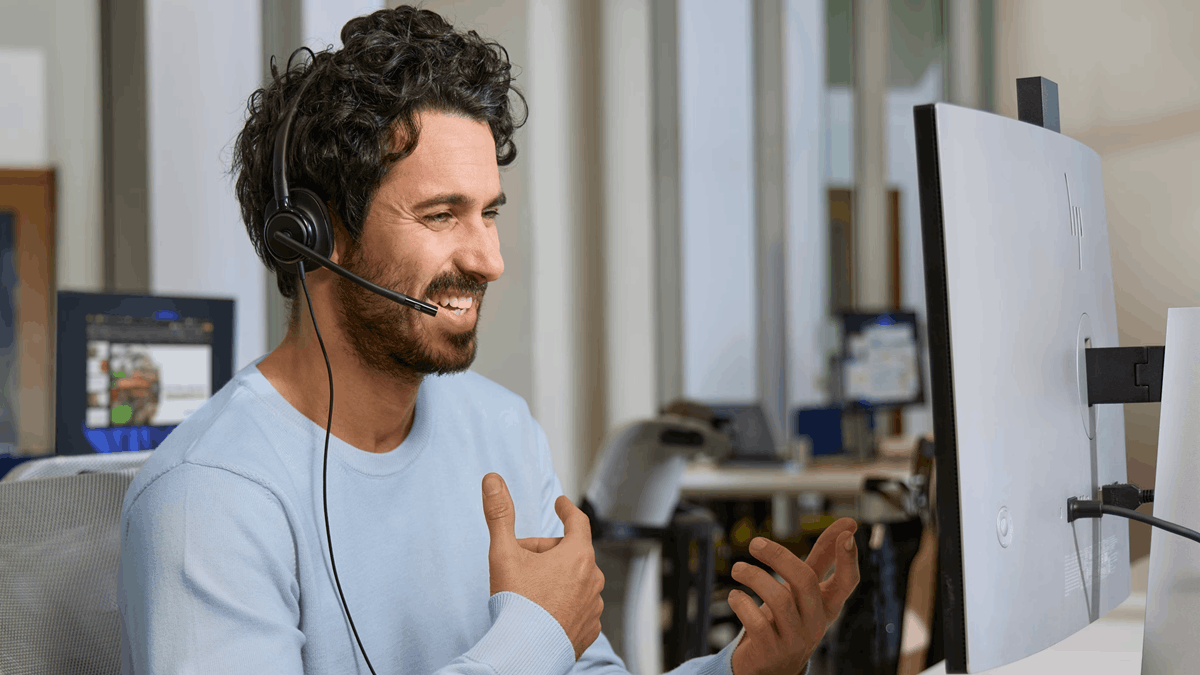 An office worker using an HP Poly Mission Series headset during a hybrid work call