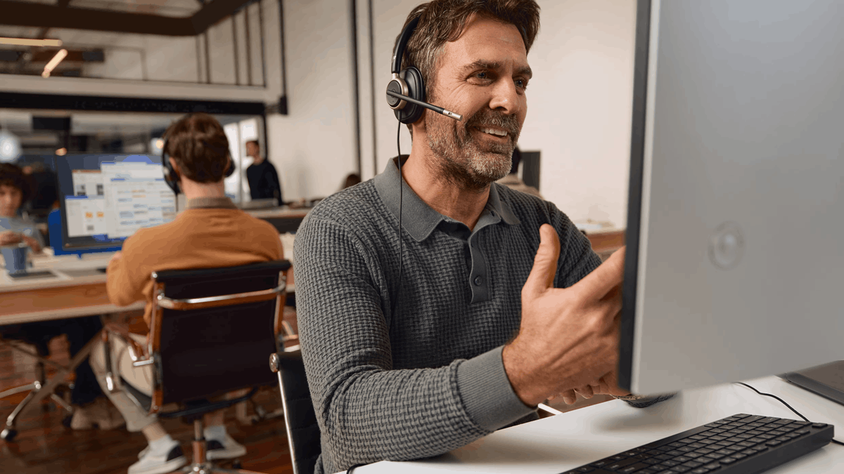 An office worker wearing an HP Poly Mission Series headset while collaborating on a video call