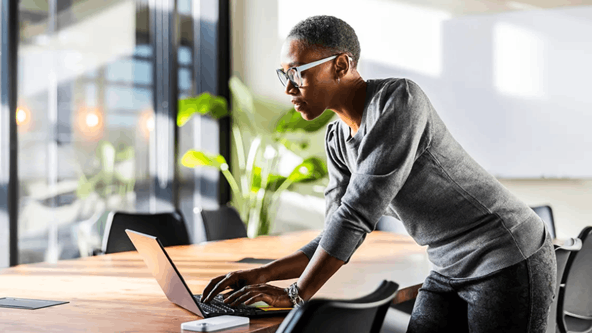Professional using a laptop in an office environment, representing AI-driven customer service workflow management
