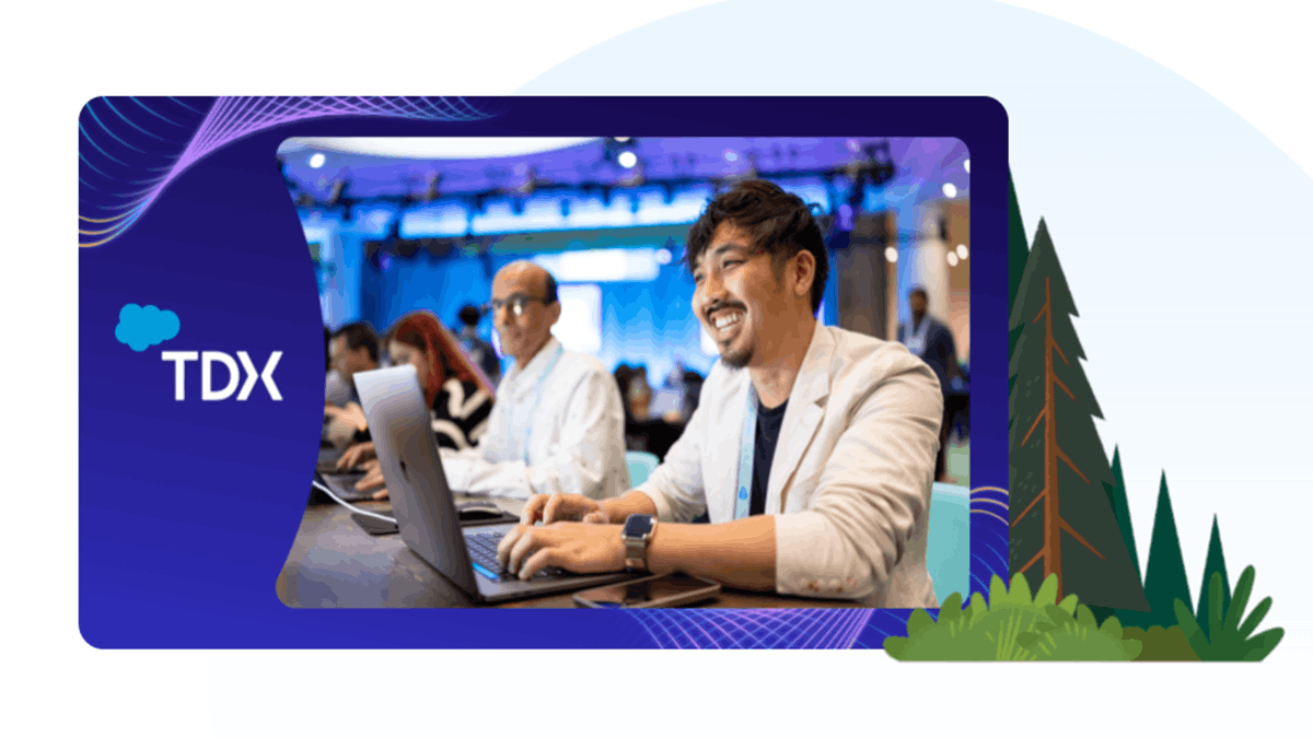 Developers working on laptops at a Salesforce TDX event, collaborating in a conference setting with a branded backdrop