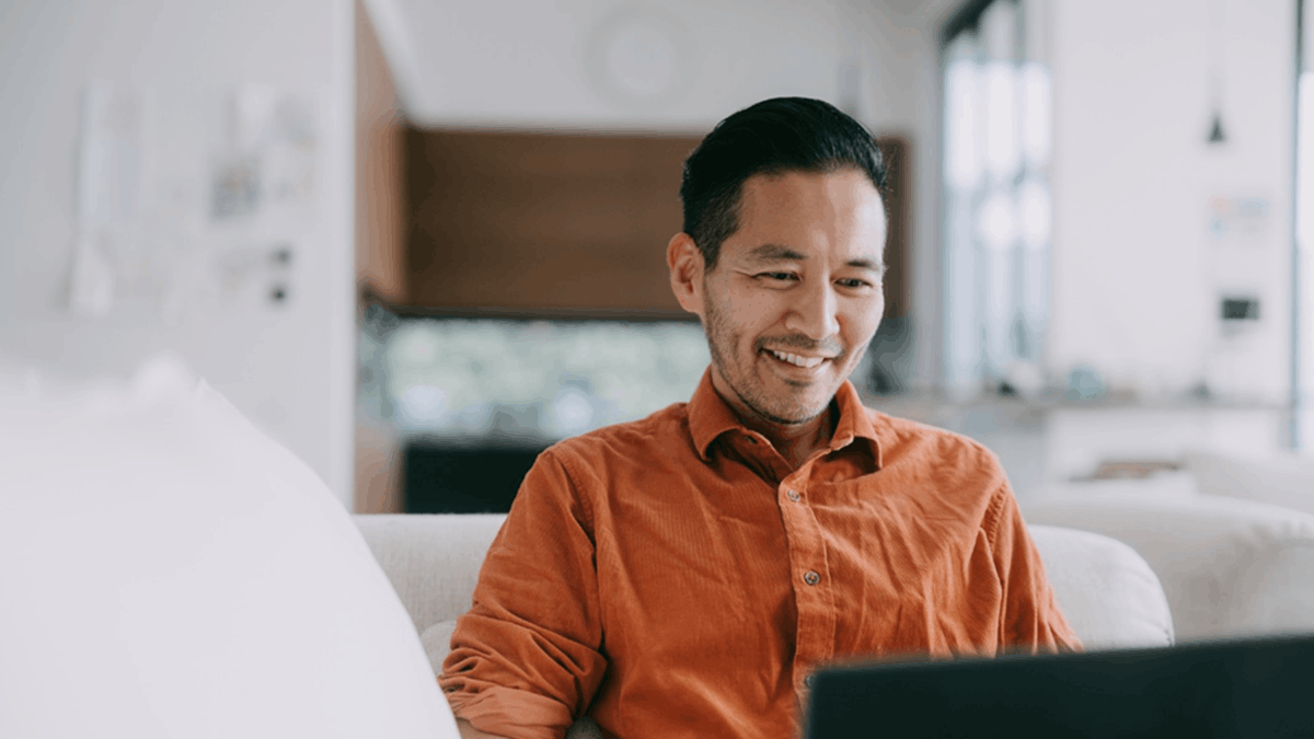 A professional using a laptop at home, representing flexible and remote customer engagement enabled by modern CX platforms
