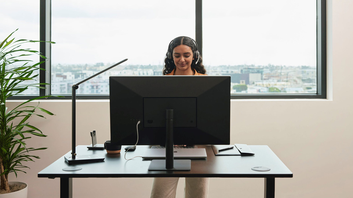 Contact center agent working on a desktop with a headset in a modern office